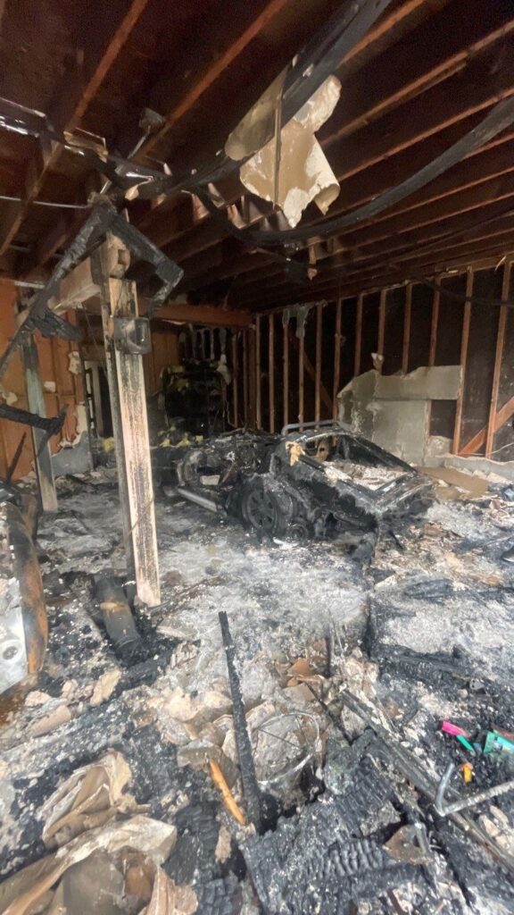 Burned out garage interior with a destroyed car after a garage fire