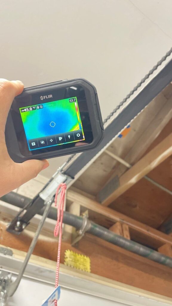 Thermal imaging camera showing a cool area on a garage ceiling during leak detection