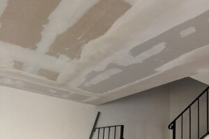 Drywall patches across a ceiling after repiping a house