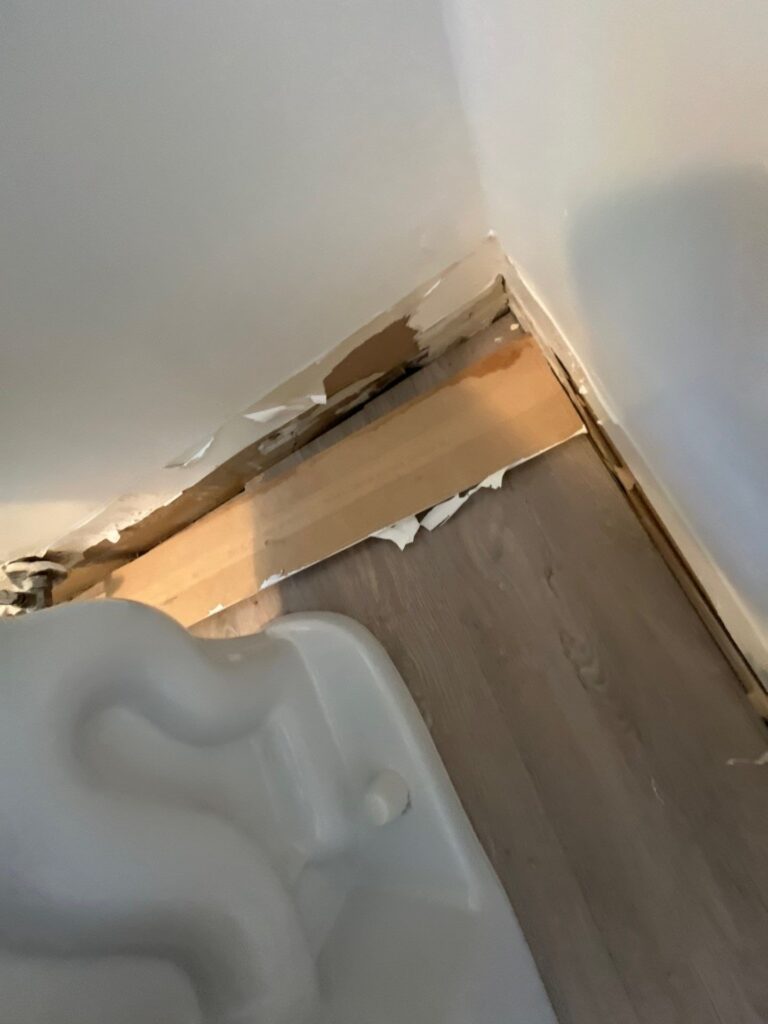 Baseboard removed next to a toilet after a sewage backup